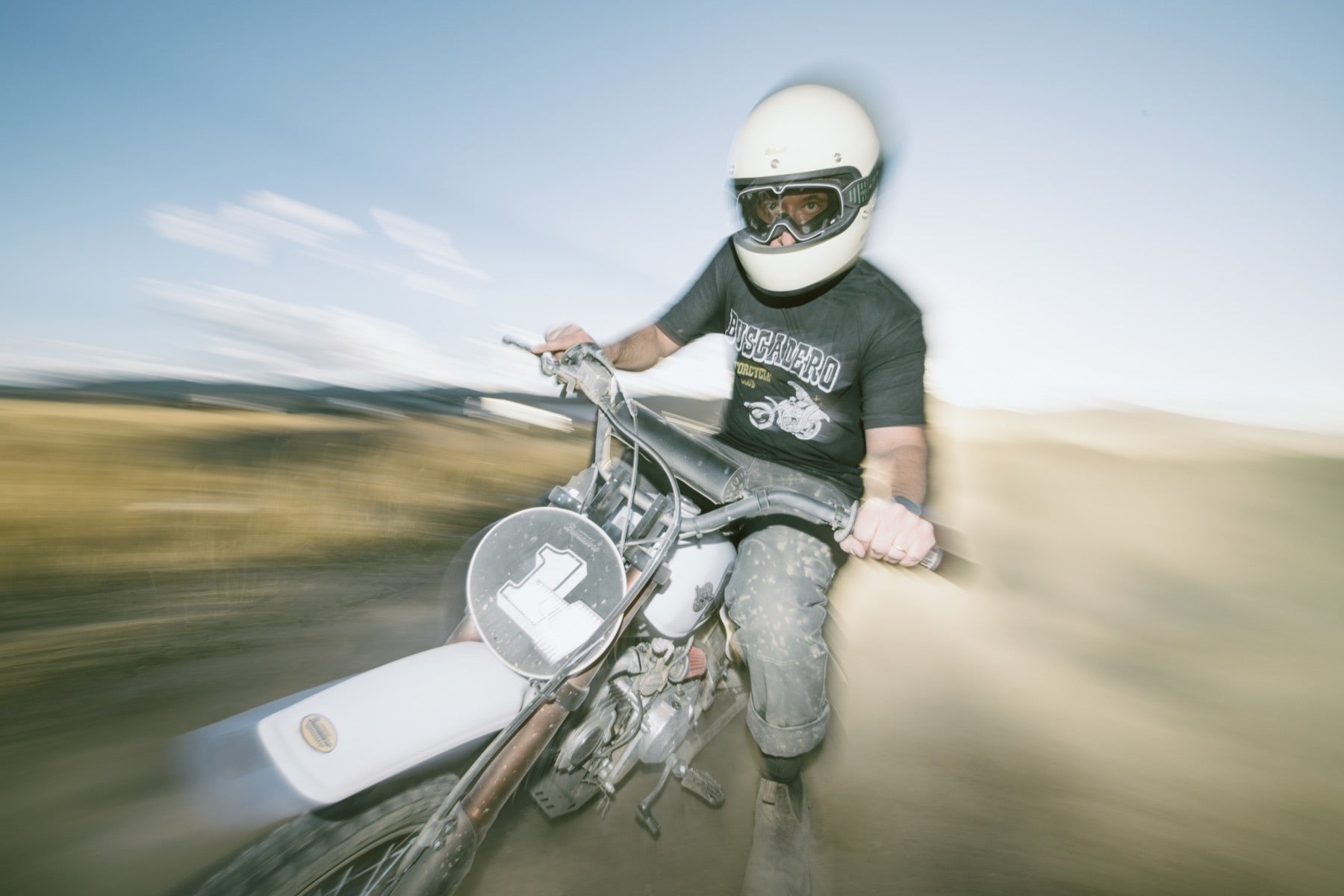 Rider enjoying a black-tank BSX 140 on a sunny dirt ride